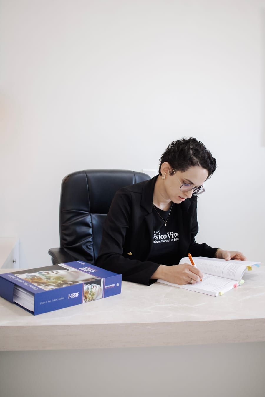 Aline Vicente fazendo anotações em sua mesa