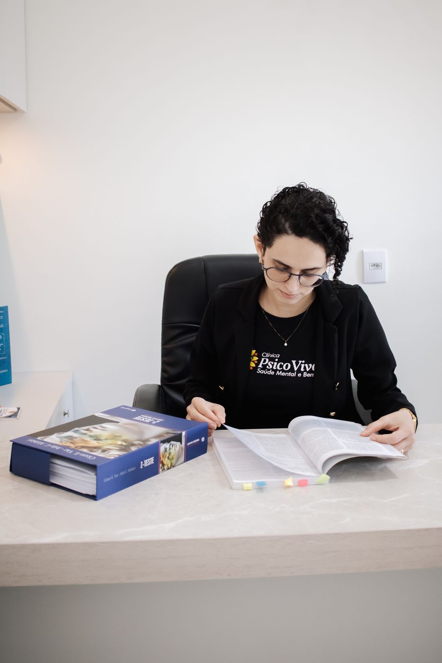 Aline Vicente estudando o manual de um teste neuropsicológico
