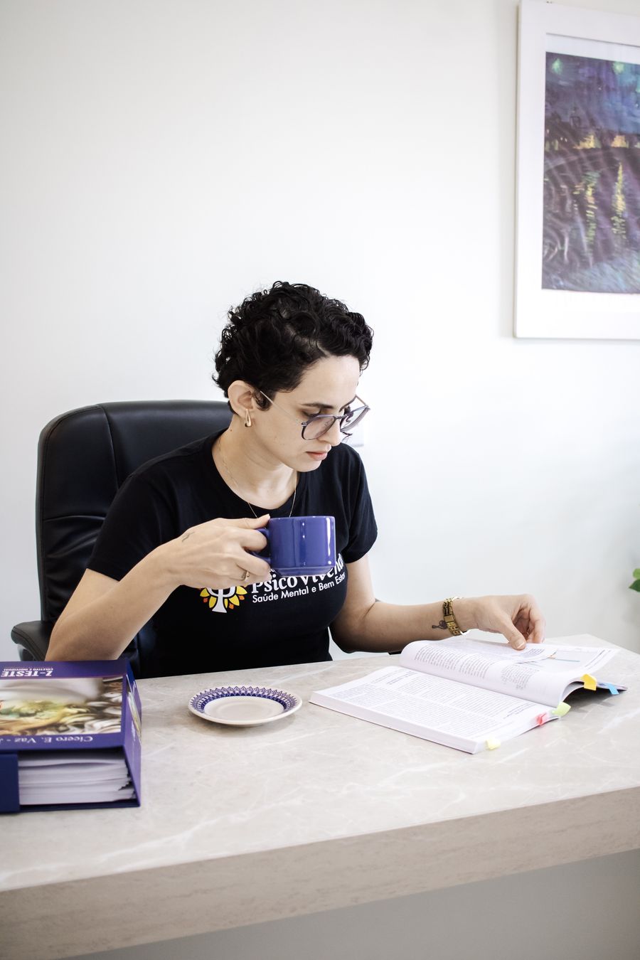 Aline Vicente lendo o manual de um teste e tomando chá